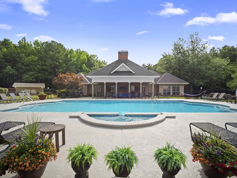 A pool with a house in the background.