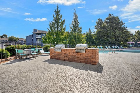 A sunny day at the pool with a red brick structure in the middle.