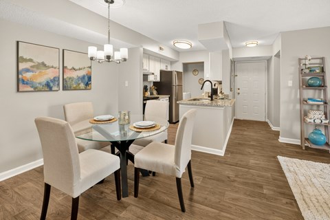 A dining room with a glass table and chairs.
