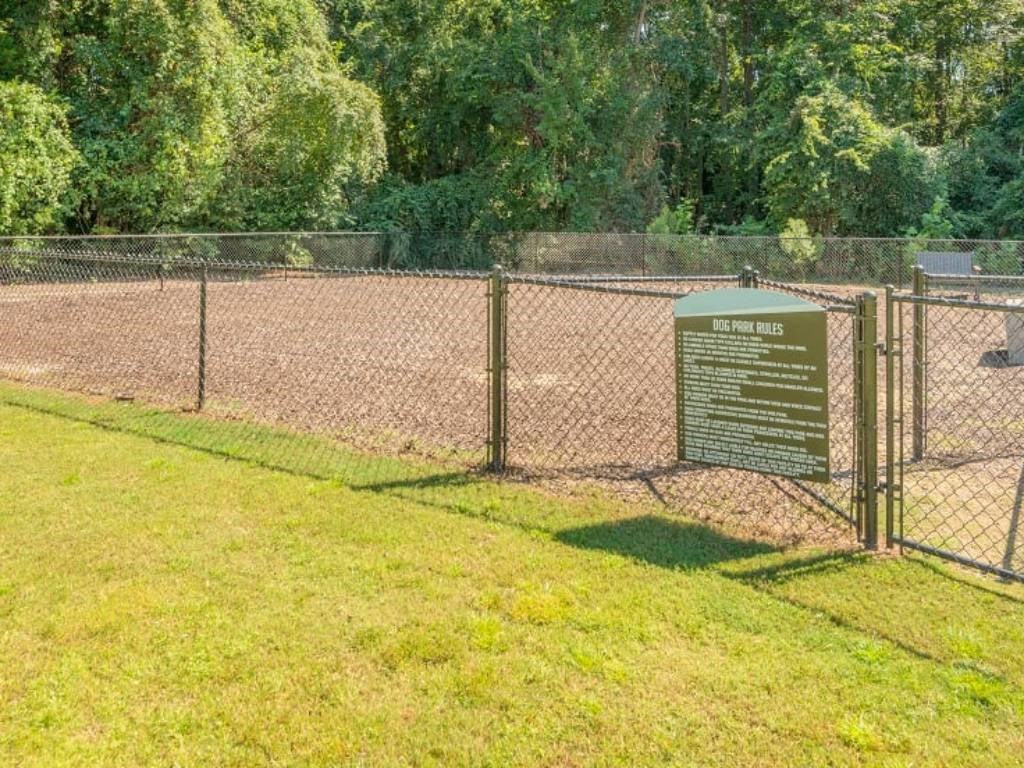 a fence with a sign on it in front of a park