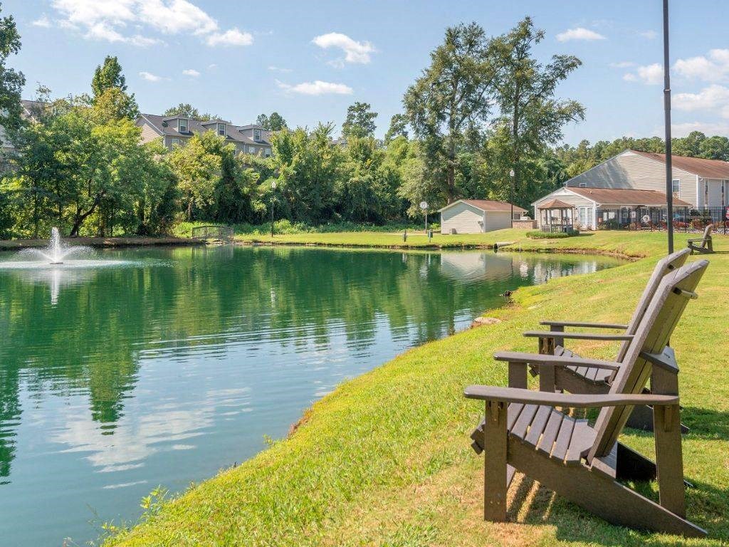 a park bench overlooking a lake with a fountain
