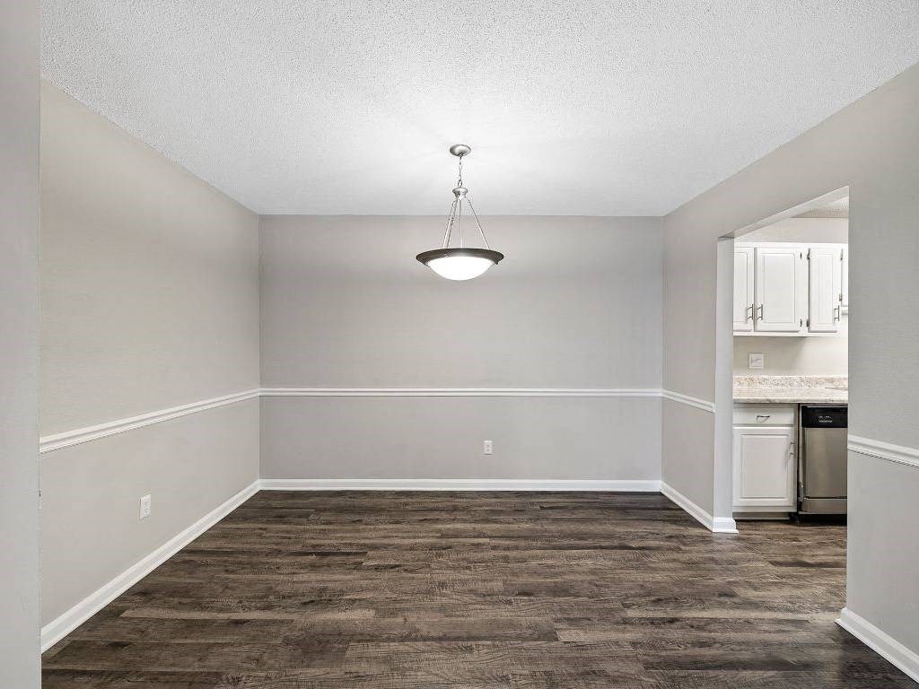 an empty living room with a light fixture in it