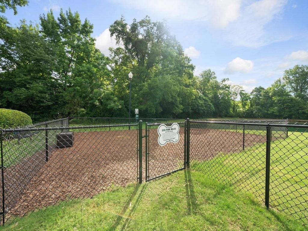 a chain link fence with a sign on it in a dog park