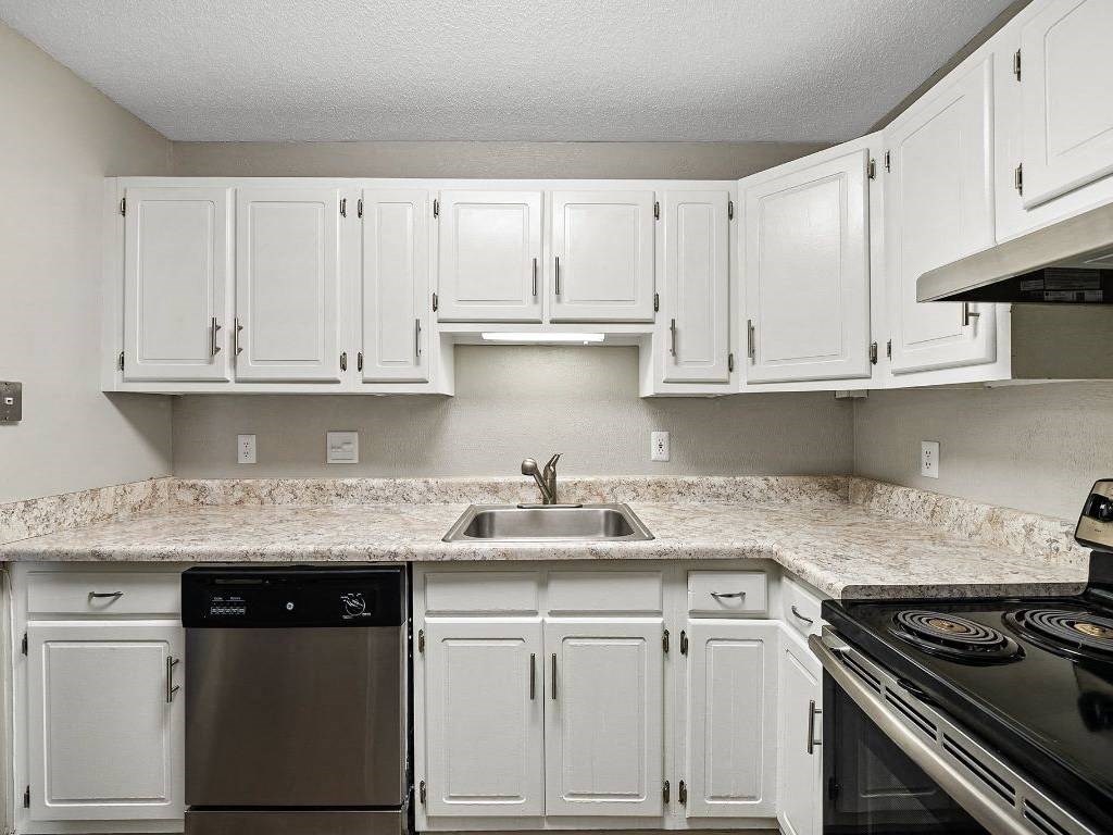 a white kitchen with white cabinets and a sink