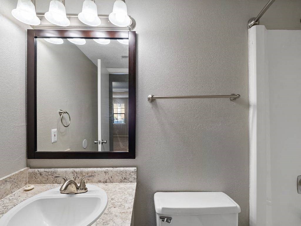 a bathroom with a mirror and a toilet and a sink