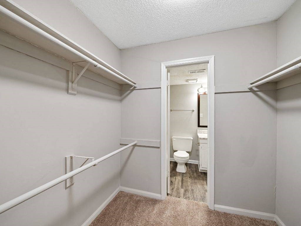 a bathroom with a toilet and a walk in closet