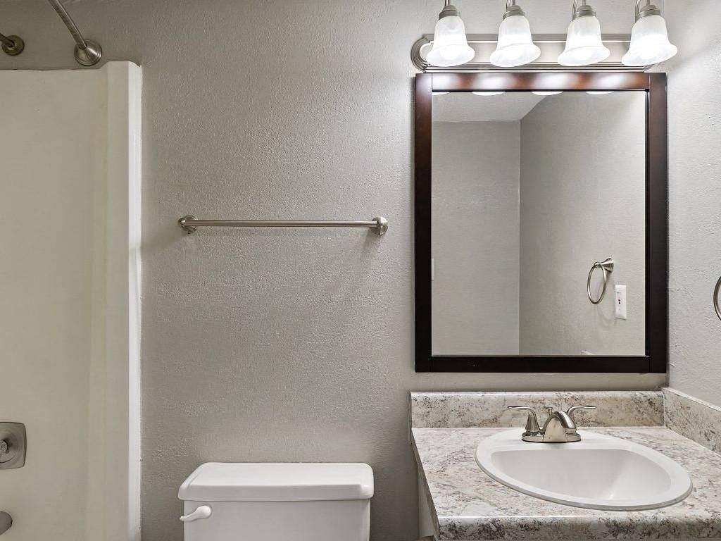 a bathroom with a toilet sink and a mirror
