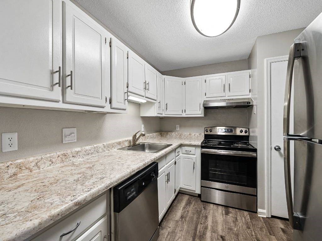 a kitchen with white cabinets and stainless steel appliances