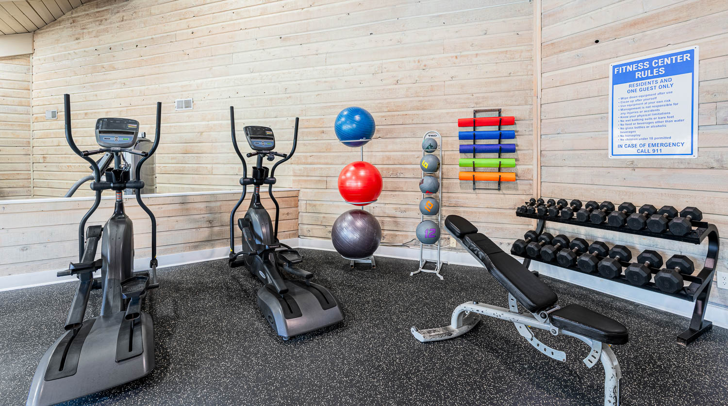 A fitness center with exercise equipment and a sign on the wall.