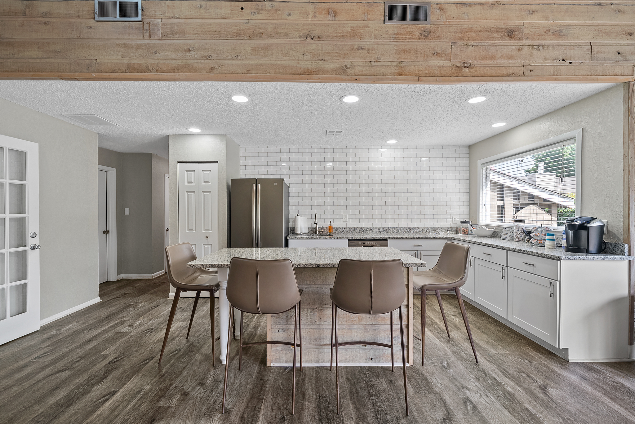 a kitchen with a large island and a table with chairs