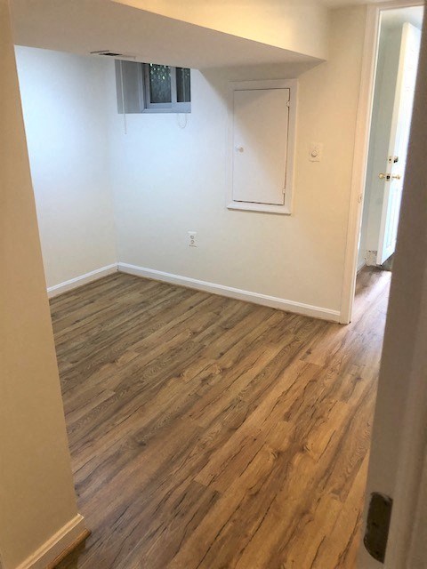 an empty room with a white wall and wooden floors