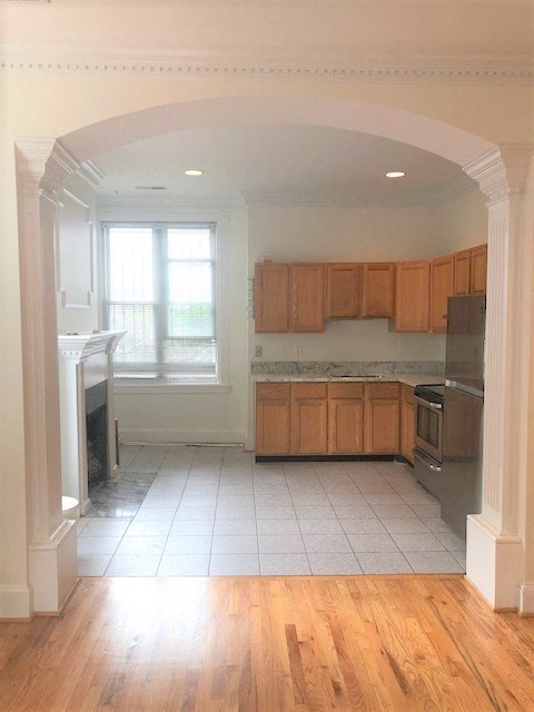 an empty kitchen with wooden cabinets and a wood floor