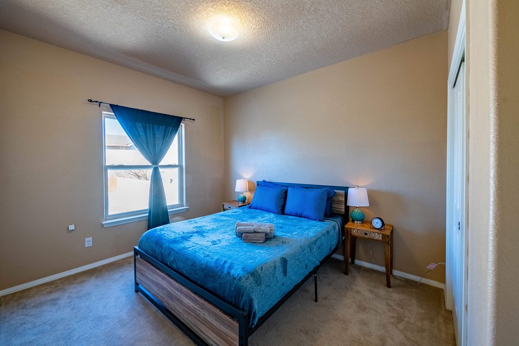 a bedroom with a blue bed and a window