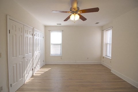 a empty room with a ceiling fan and a door