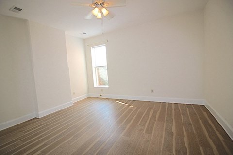 a empty room with a ceiling fan and a window