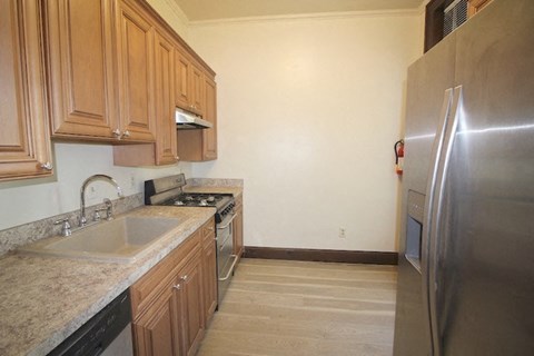 a kitchen with a sink and a stainless steel refrigerator