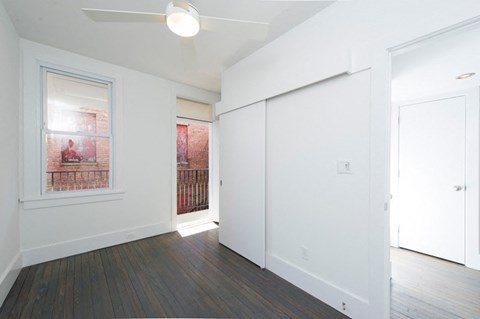 an empty living room with white walls and a door to a balcony
