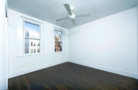 an empty room with a ceiling fan and a window