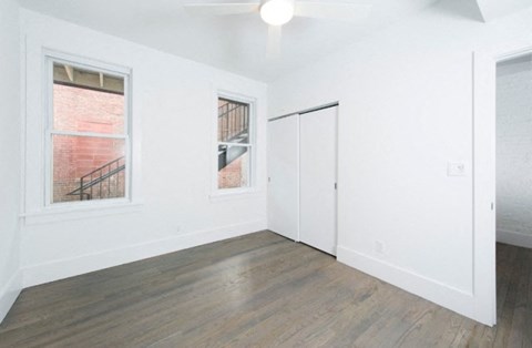 an empty living room with white walls and wood floors