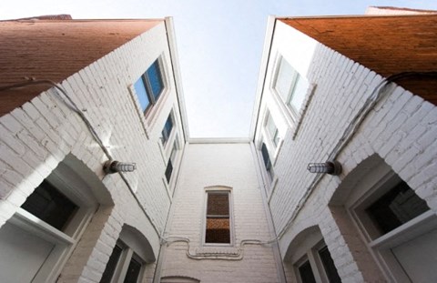 an upward view of a white brick building with windows