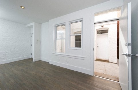 an empty living room with white walls and wood floors