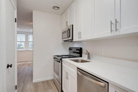 a kitchen with white cabinets and a sink and a microwave