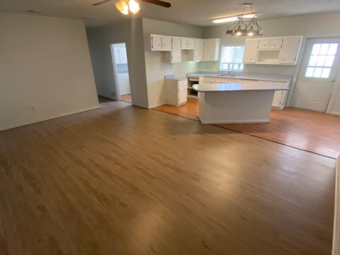 an open kitchen and living room with wood flooring