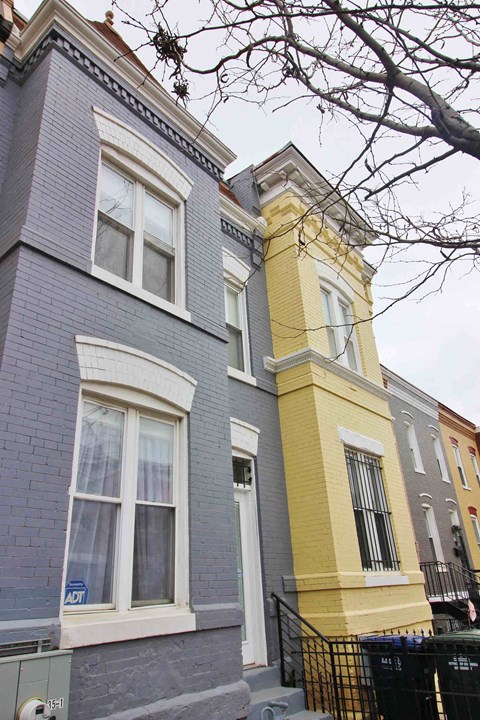 A row of houses with different colored fronts.