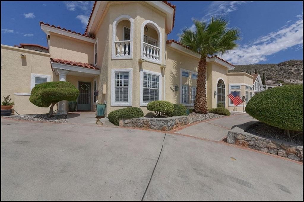a house with a driveway and a palm tree in front of it