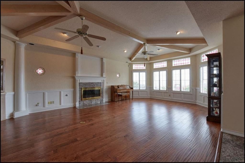 a large living room with a fireplace and wooden floors
