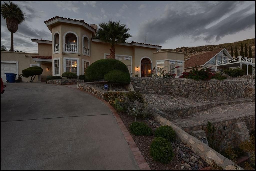 a house with a driveway and a palm tree in front of it