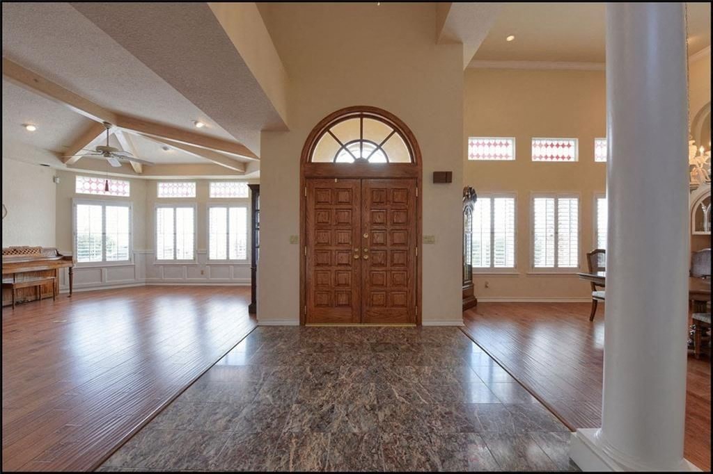 an empty living room with wood floors and a wooden door