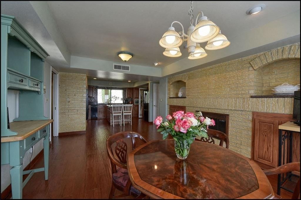 a dining room with a table and a vase of flowers