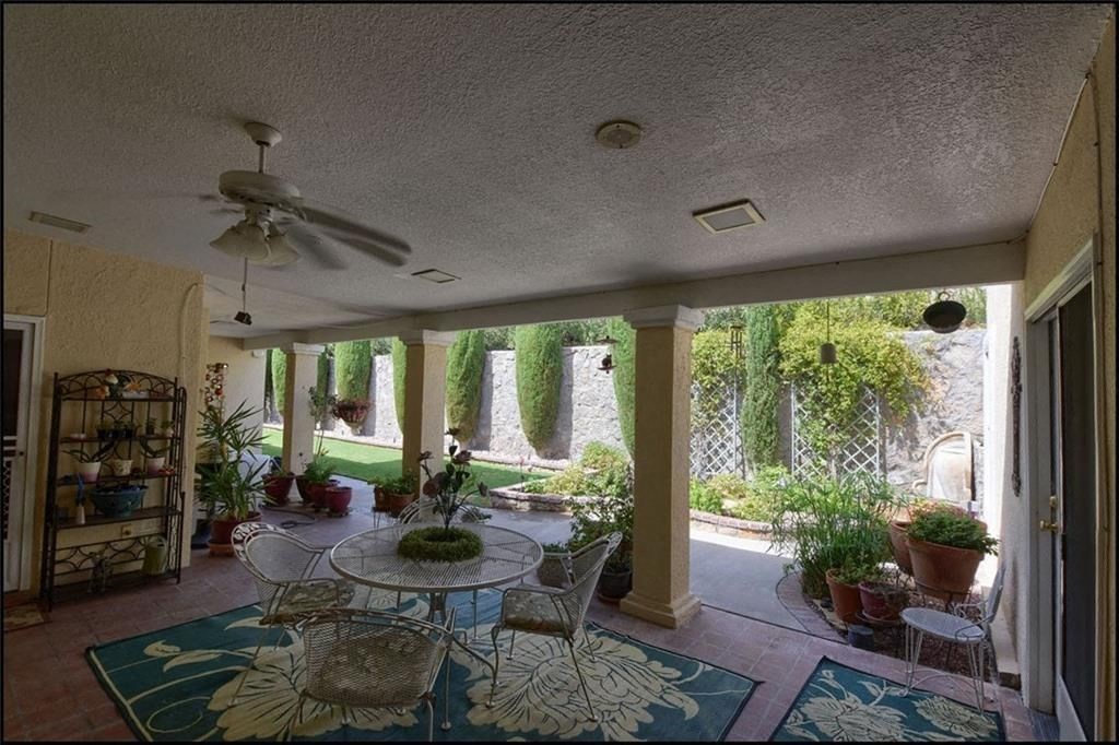 a patio with a table and chairs and a ceiling fan