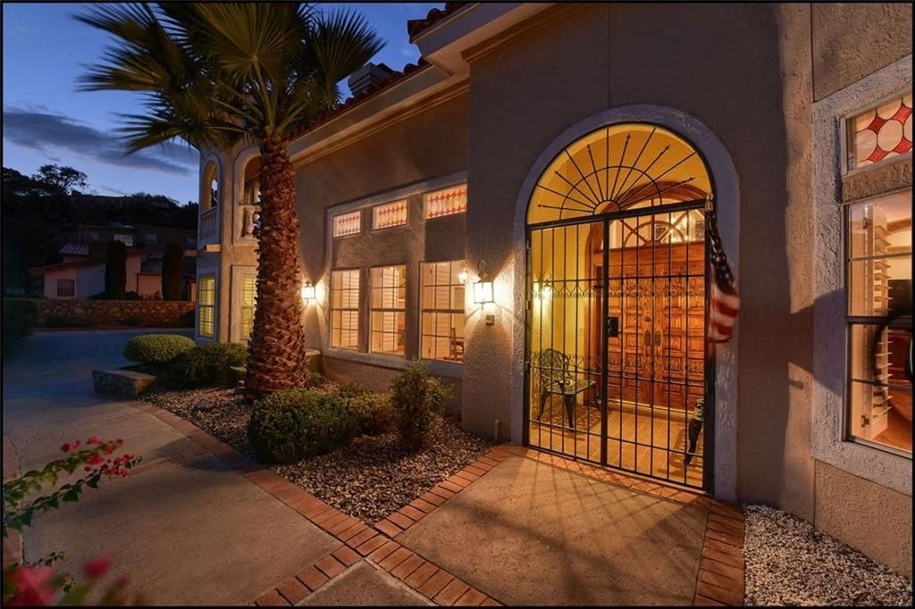 the front door of a house at night with a palm tree