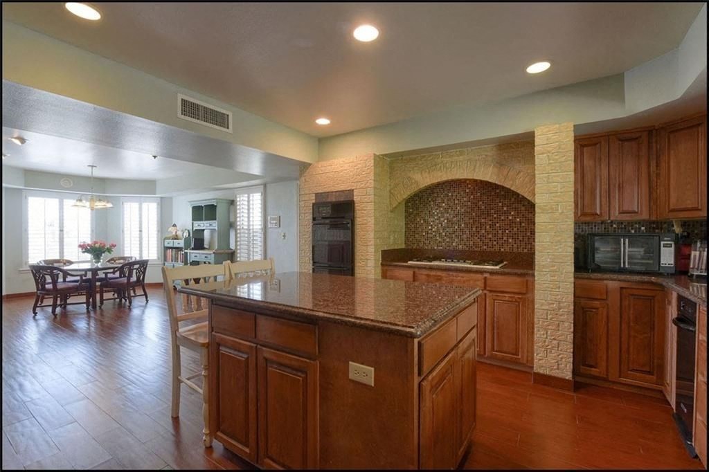 a large kitchen with an island and a dining room