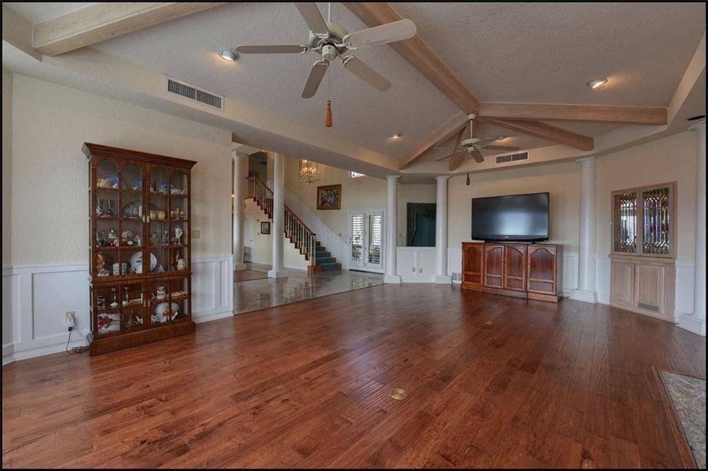 a large living room with a wood floor and a ceiling fan