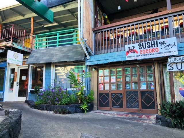 a building with a sushi shop and a restaurant on the street