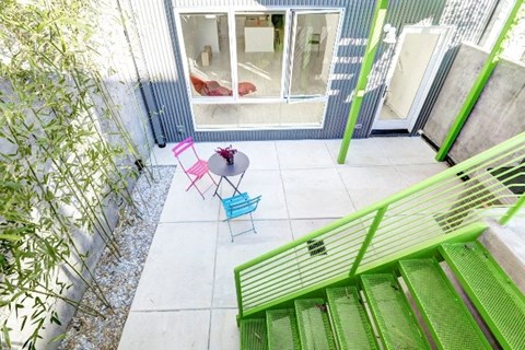 A balcony with a table and chairs.