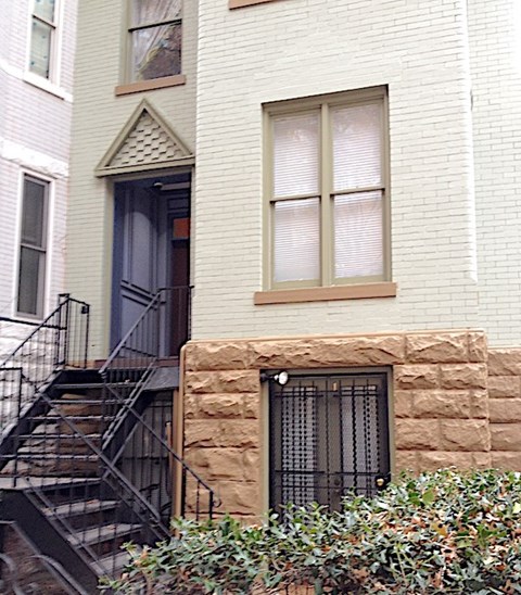 a white house with a window and stairs