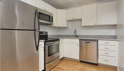 a kitchen with stainless steel appliances and white cabinets
