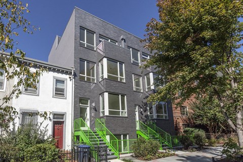 the exterior of a building with green stairs