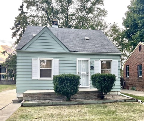 A small house with a white door and two windows.