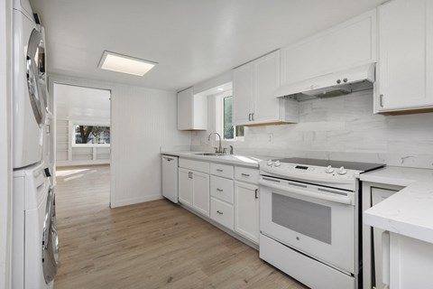 a white kitchen with white appliances and white cabinets
