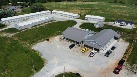 an aerial view of a farm with cars parked in a parking lot