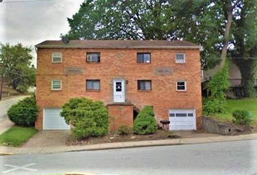 a brick house on the side of a street