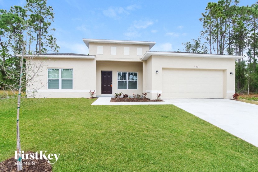 a white house with a lawn and a driveway