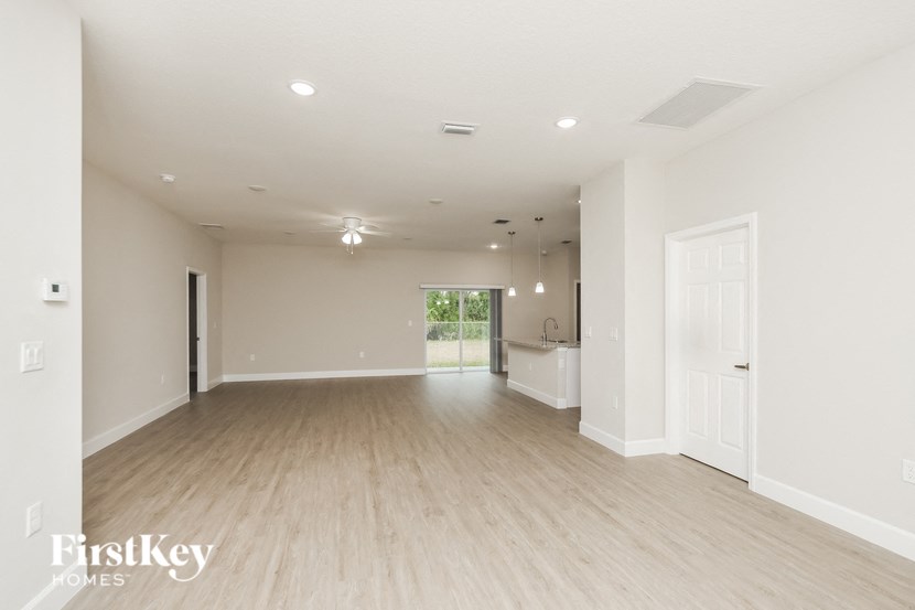 an empty living room with white walls and wood floors