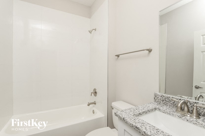 a white bathroom with a tub and a sink and a toilet