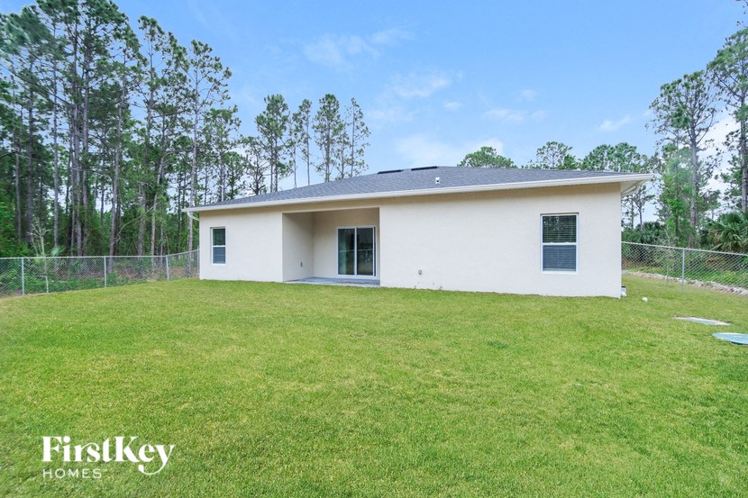 a small white house with a yard and a fence